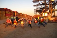 Construction workers stretching on a job site.