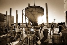 Construction workers performing a concrete pour on a jobsite.