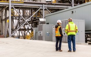 Two people talking outside dry fly facility