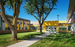 Two trees line a walkway outside Beveridge Magnet Middle School.