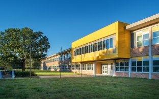 The front entrance Beveridge Magnet Middle School with a large yellow upper floor.