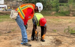 Two people looking at equipment on the ground