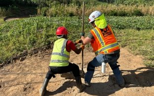 Two people working together with a piece of equipment