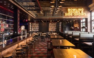 Bar area with high top tables and chairs as well as booths