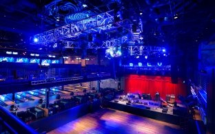 Aerial view of a stage and dance floor with bowling lanes in the background.