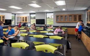 People working in various areas in a classroom