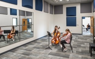 People practicing instruments in a band hall room