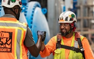 Two people fist-bumping on a jobsite. 