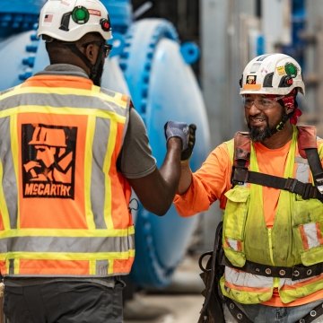 Two people fist-bumping on a jobsite. 