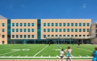 Exterior view of the specialty center building with the turf football field in the foreground