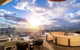 A rooftop lounge area with chairs and couches