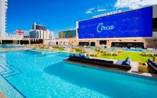 Rooftop swimming pool with a large screen reading "Circa"