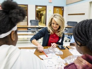 employee volunteering at a school doing an activity