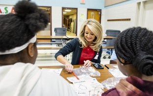 employee volunteering at a school doing an activity