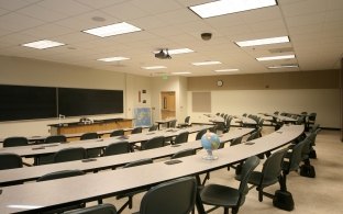 A classroom with long tables and chairs.