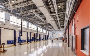 An automotive shop area with car lifts and high ceilings