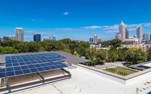 Solar panels on the roof with city buildings in the background