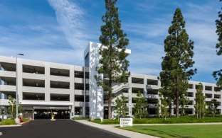 A view of the Hyundai Parking Structure from the tree-lined campus.