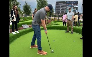 An intern playing mini golf at the intern kickoff event