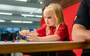 A child building with Legos at the table