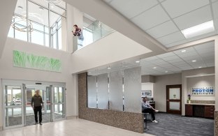 Interior view of the entrance to KC Proton Institute, showing a second floor balcony inside. 