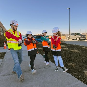 Construction worker stretching with a few kids