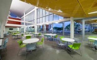 Interior image of an area with round tables and multiple colored chairs