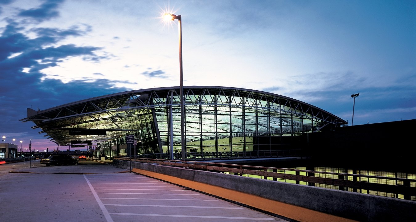 Outdoor image of a terminal thats completely glass and steal with clouds in the sky