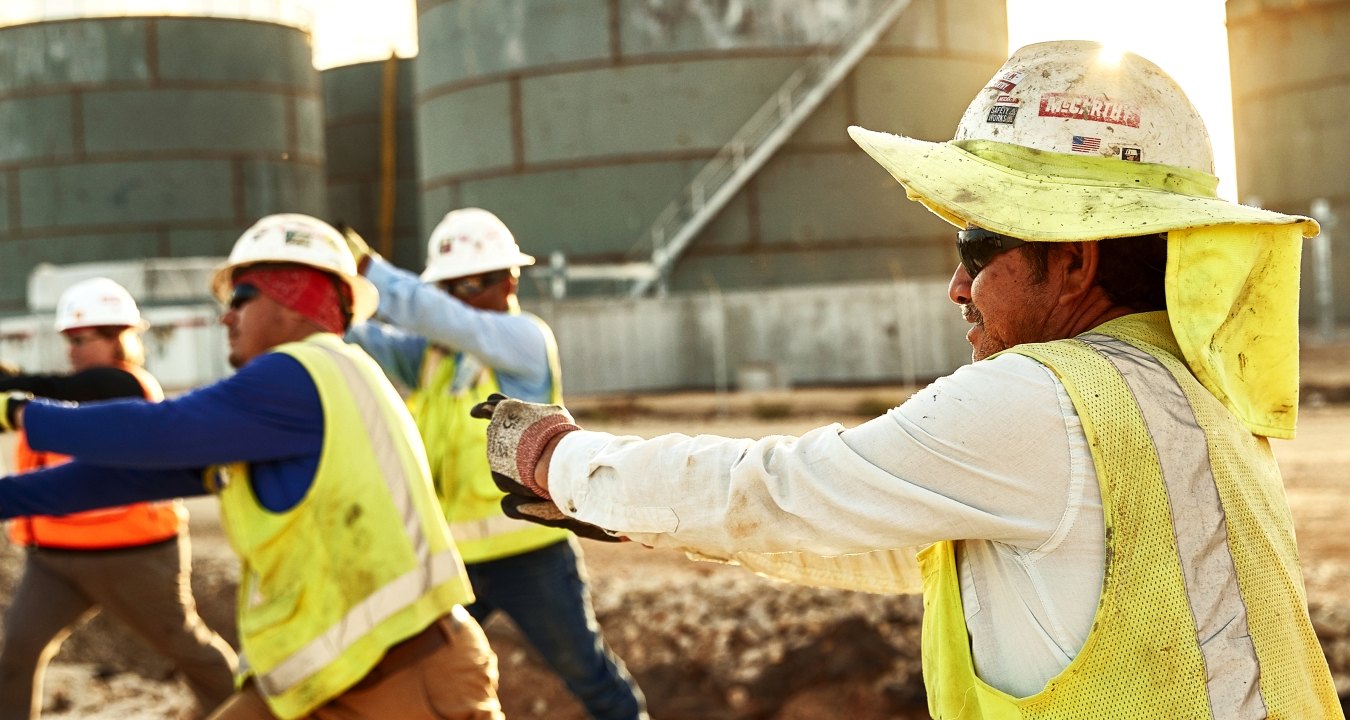 Construction workers stretching on the jobsite.