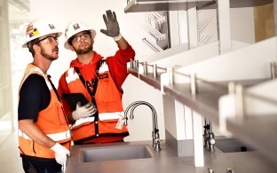 Two construction workers talking in a lab.