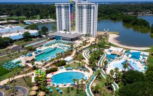 Aerial exterior view of the resort tower with the pools in front and the lake behind