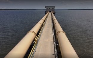 Long pipes leading to the intake pump station in the middle of the water