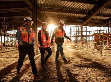 Three people walking a jobsite.