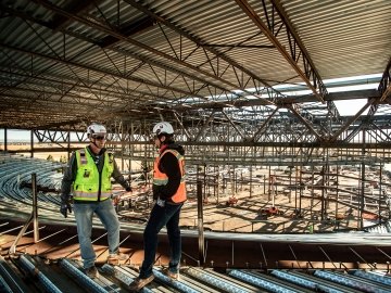 Two construction workers talking on a jobsite.