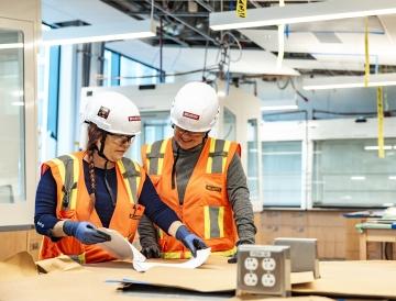 employees in lab looking at plans