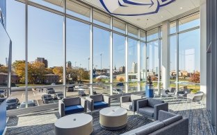 A sitting area with couches and large, floor-to-ceiling windows in the background.