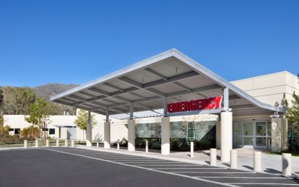 Outdoor entrance to the emergency room with trees and hills in the background