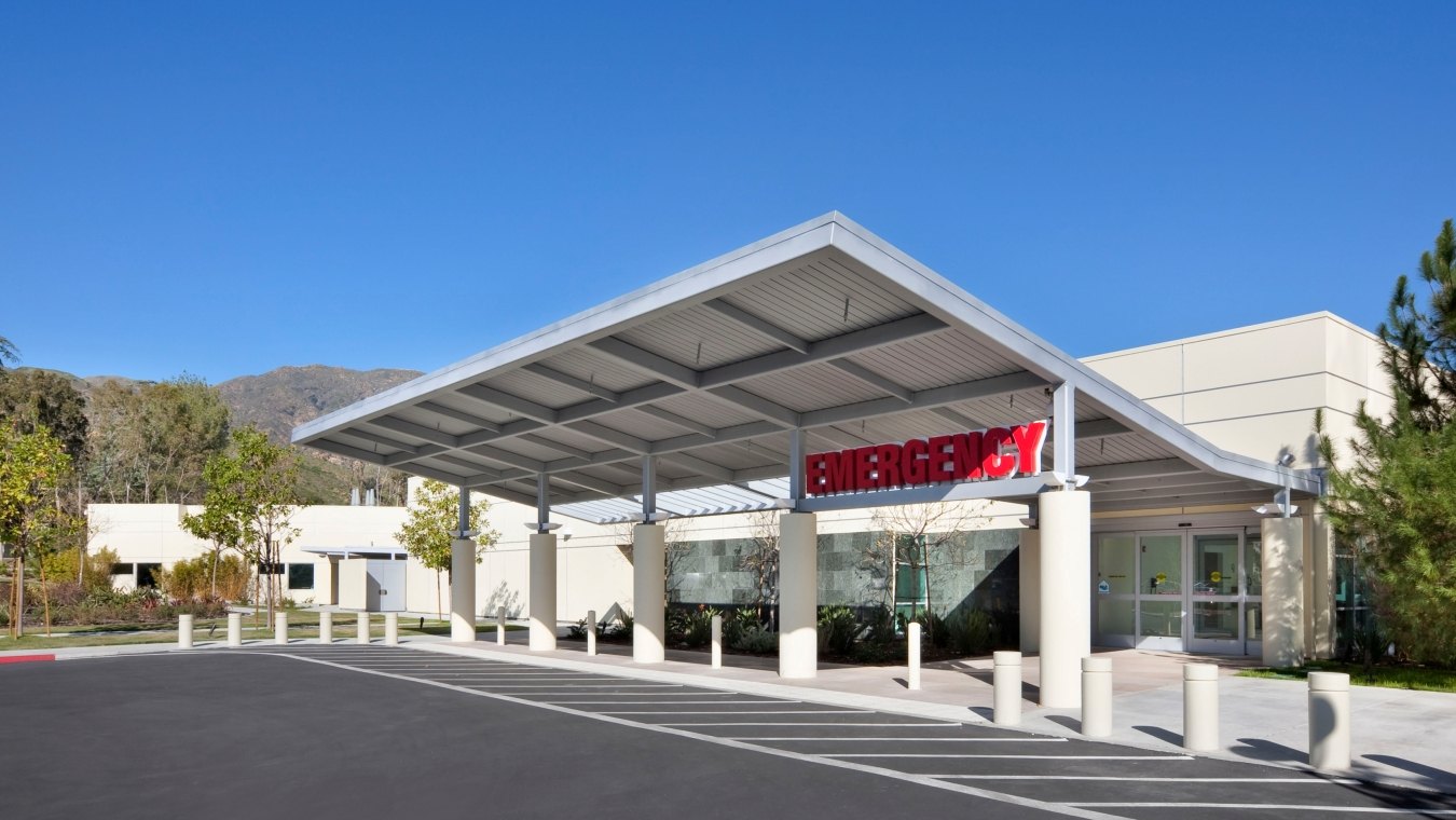 Outdoor entrance to the emergency room with trees and hills in the background