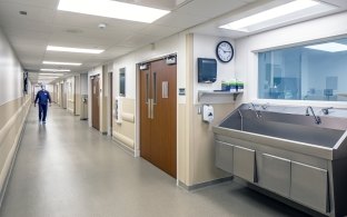 View of a hallway with a sink at the forefront of the photo. 