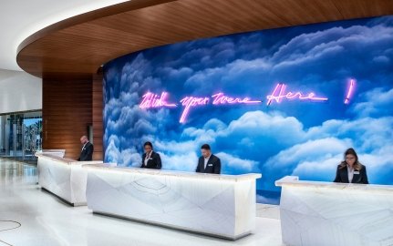 People working at the front desk of the resort with art on the wall in the background