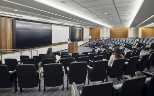 An auditorium with chairs and a large screen