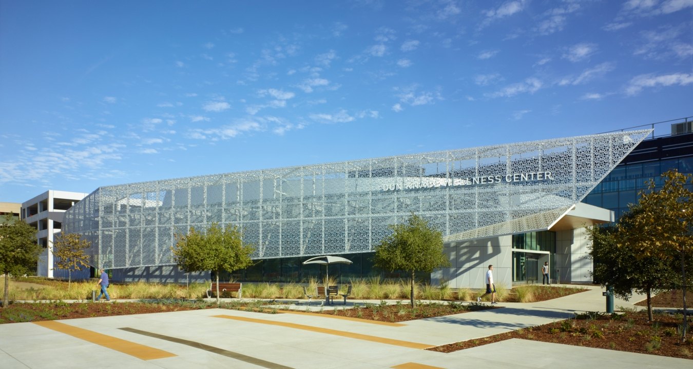 Entrance and front of the rehabilitation center structure that features a blue sky and the parking lot