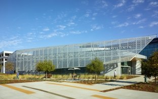 Entrance and front of the rehabilitation center structure that features a blue sky and the parking lot