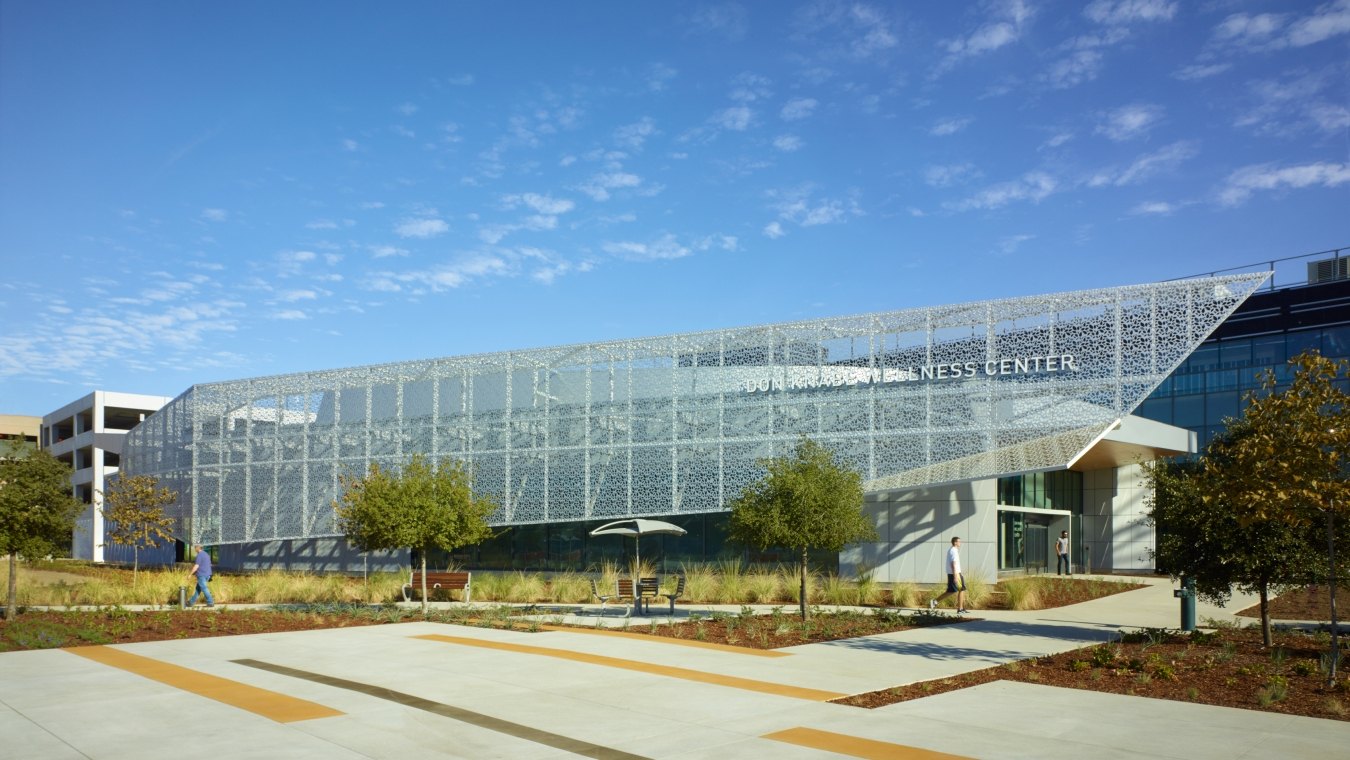 Entrance and front of the rehabilitation center structure that features a blue sky and the parking lot