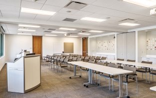 Indoor image of a training room with all chairs and desks facing the same way