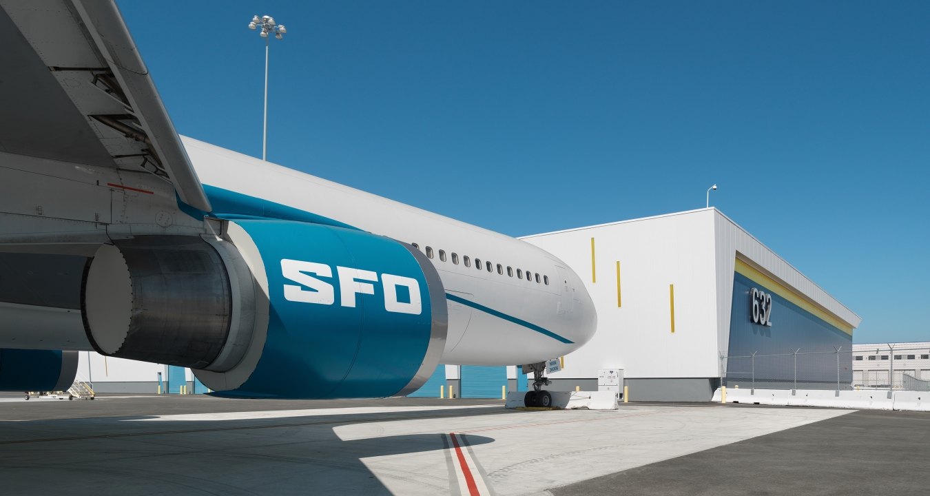 A parked airplane with letters SFO on the engine.