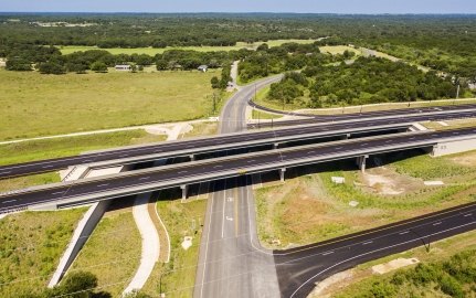 Highway with lots of greenery around and road going under