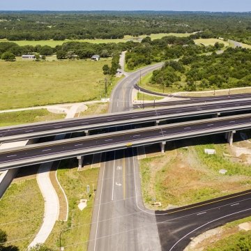 Highway with lots of greenery around and road going under