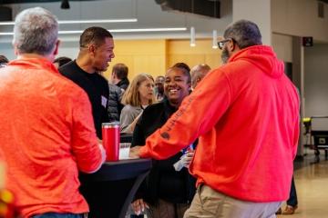 People standing around a table talking.