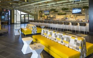 Lounge area with a yellow couch and some tables